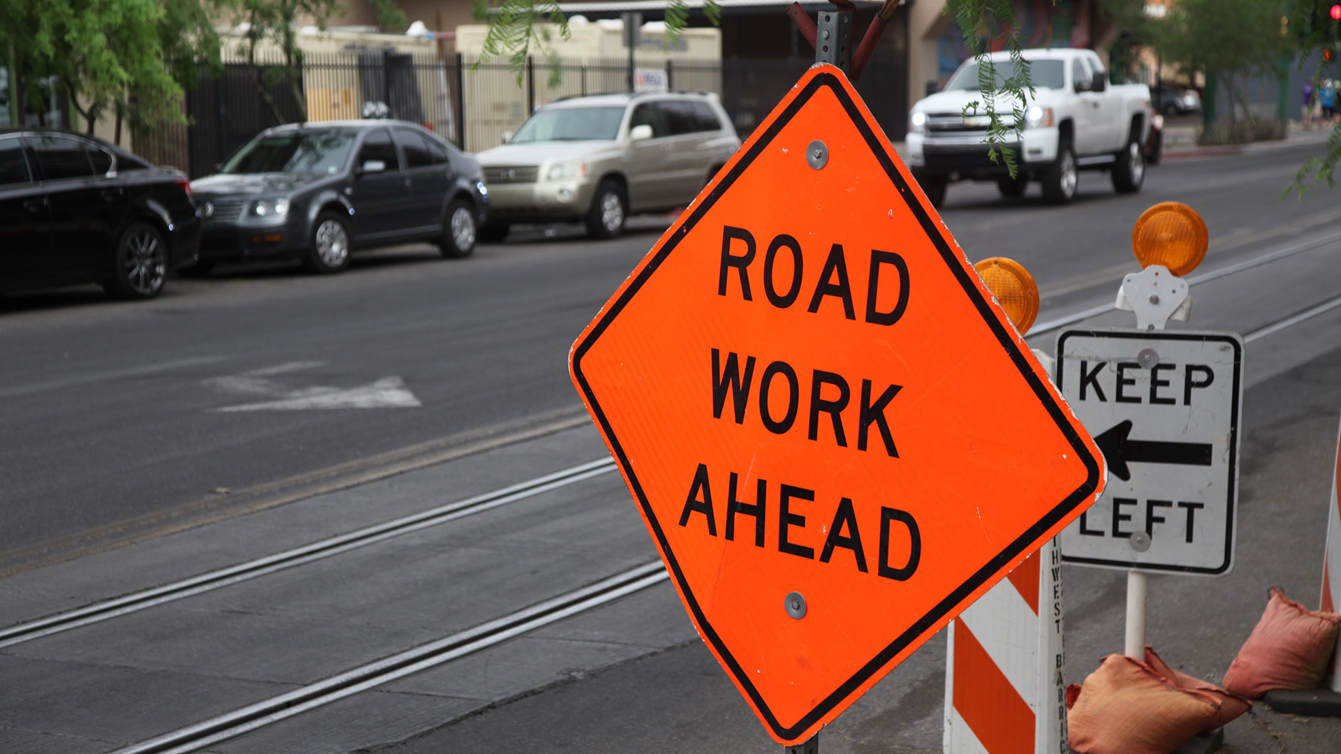 A construction sign along a street that says road work ahead.