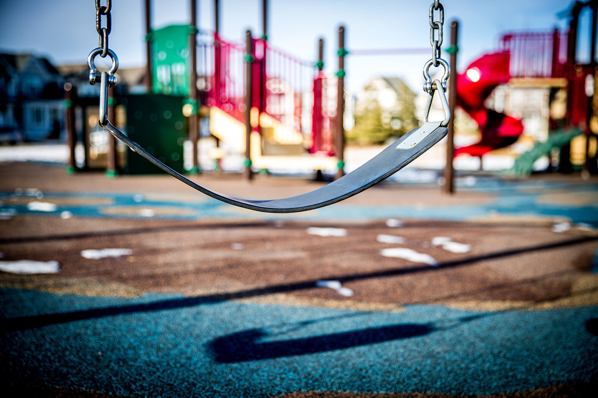 A closeup of a swing seat on a playground.